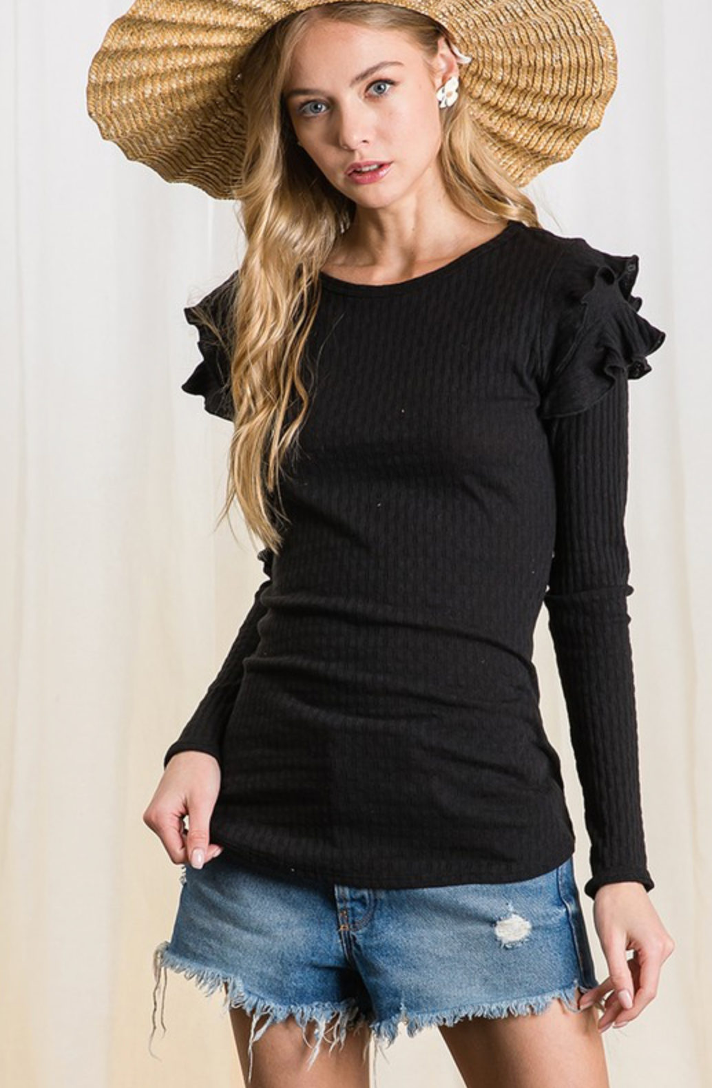 Long sleeve black ruffle sleeve top. model wearing a hat that makes you say wow, what a hat